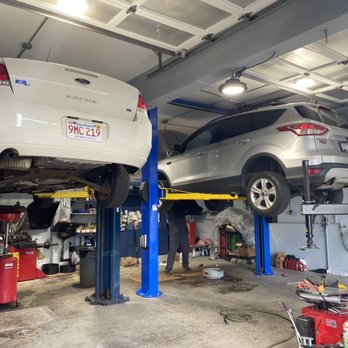 Two cars up on lifts in the service bay